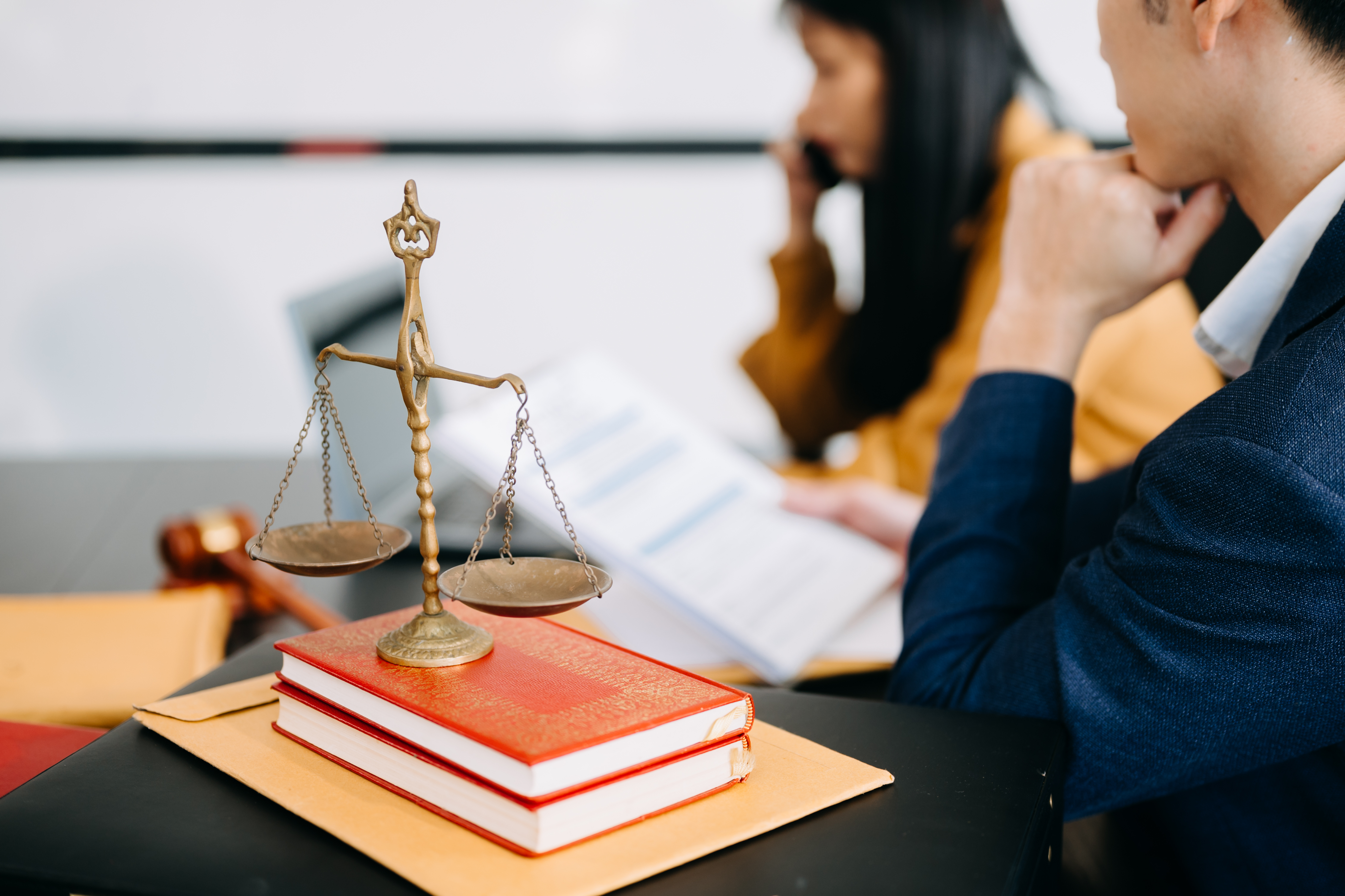 Male lawyer in the office with brass scale on wooden table. just