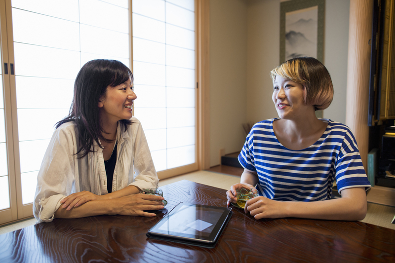Osaka,Japan,Two women sitting at a table with a digital tablet.